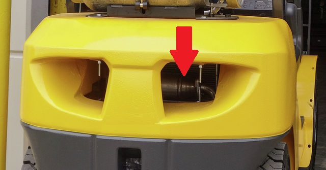 The backside of a Komatsu forklift where is highlighted the location of its muffler with a red arrow